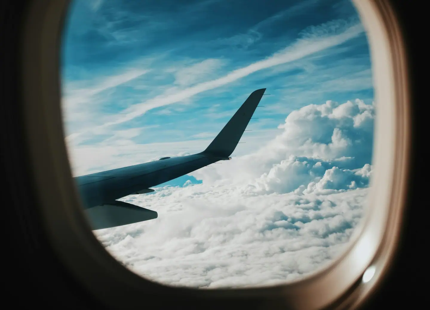 Ala de un avión sobre las nubes vista a través de la ventanilla