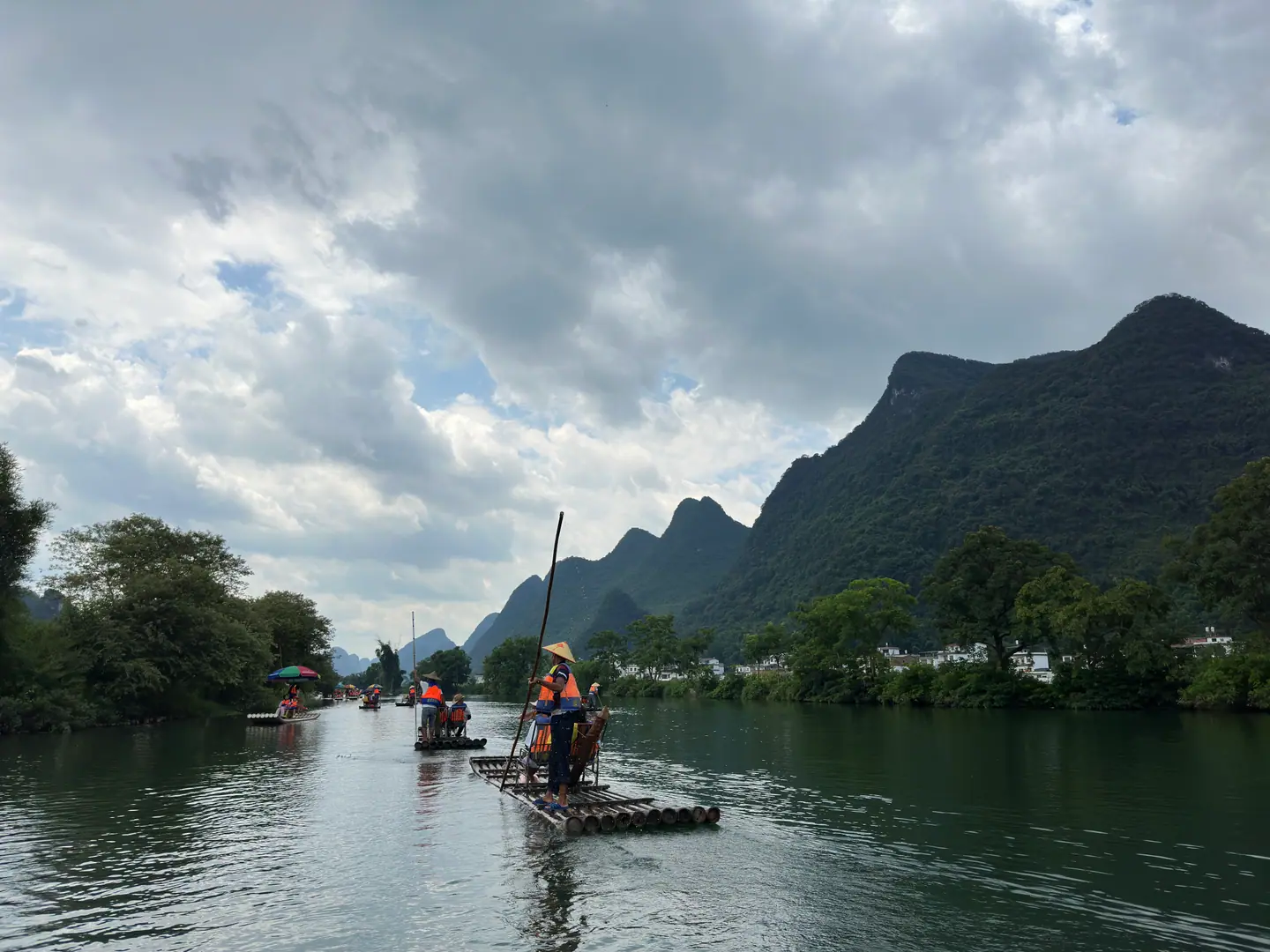 Balsas de bambú navegando por el río Yulong entre montañas kársticas, Yangshuo