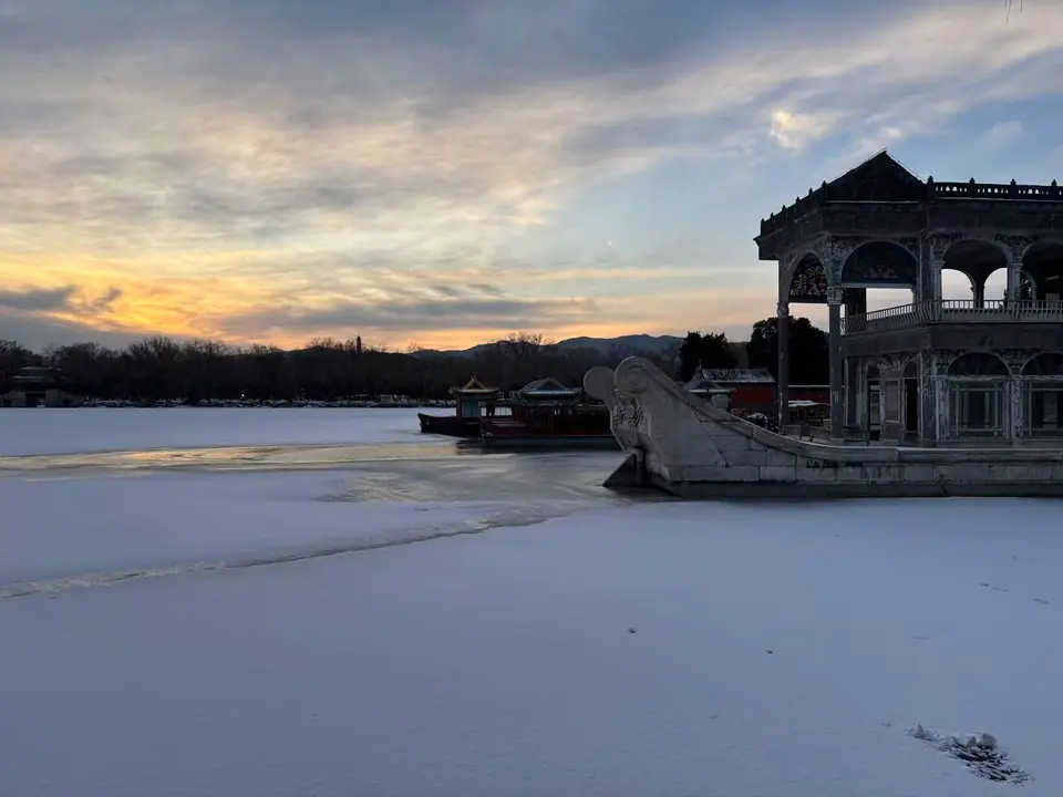 Barco de mármol junto al lago Kunming helado al atardecer en el Palacio de Verano, Pekín