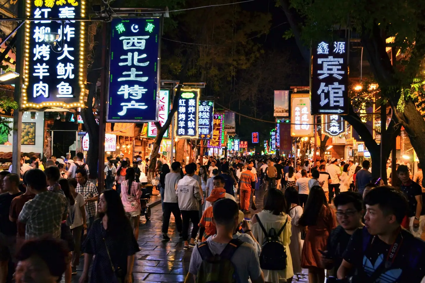 Calle del Barrio Musulmán de Xi'an por la noche, llena de gente y de letreros luminosos