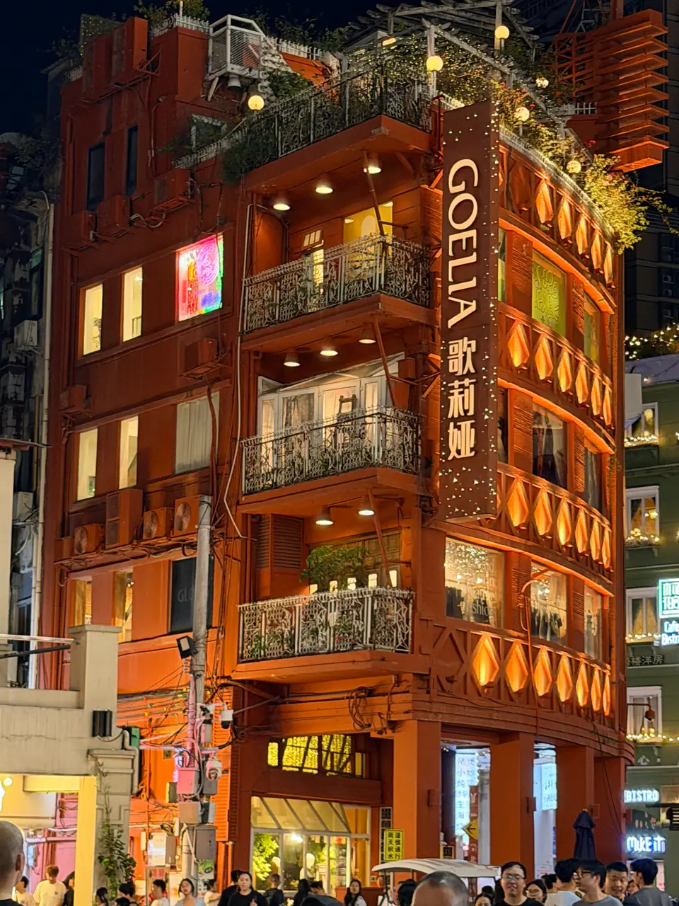 Edificio histórico iluminado en una animada calle comercial de Cantón