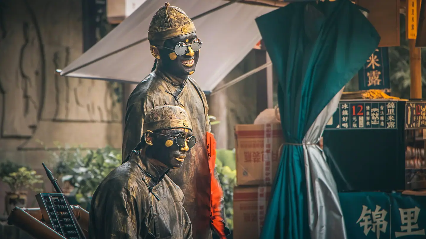 Estatuas de bronce junto al letrero de Jinli, la calle tradicional de Chengdu