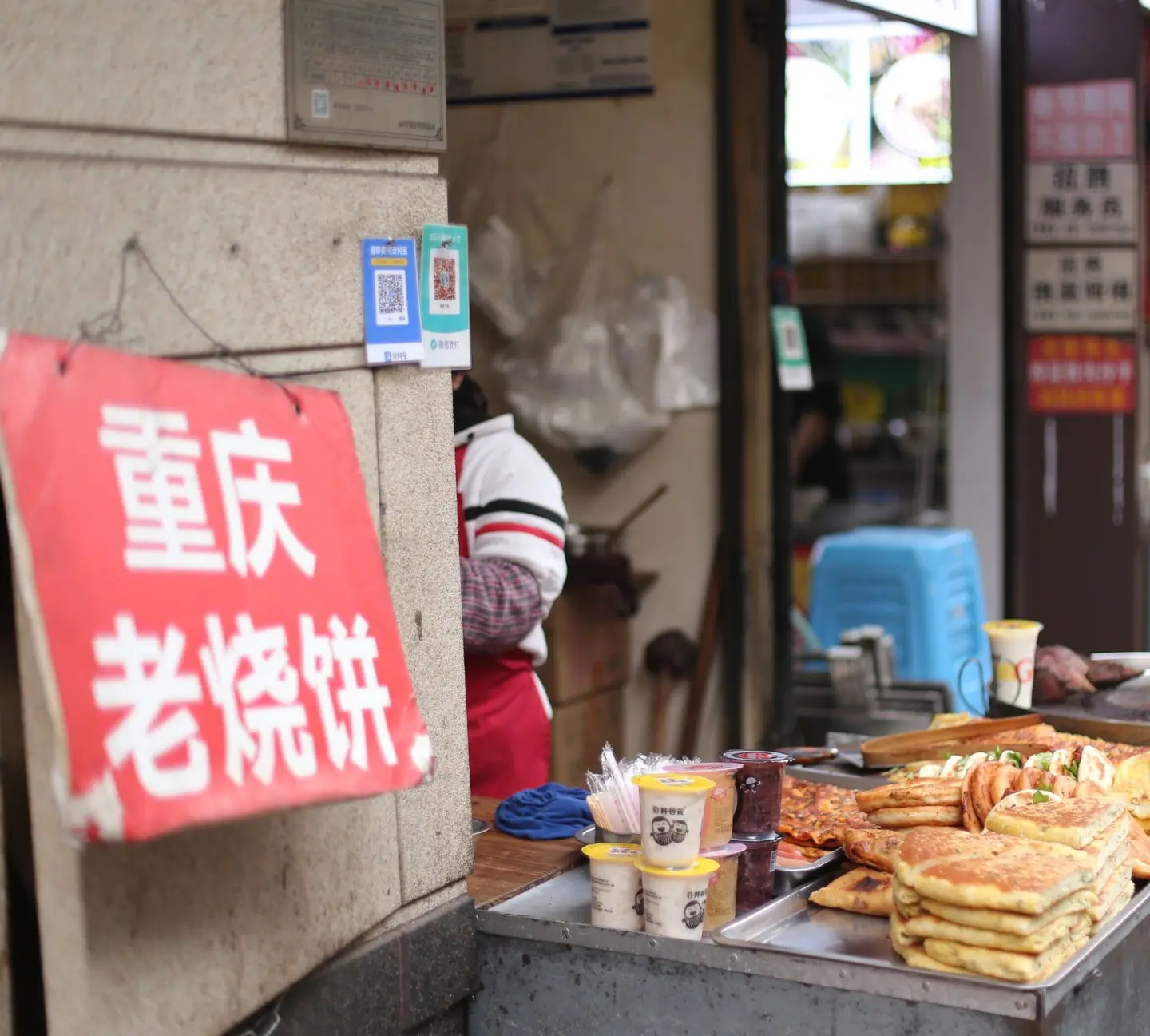 Adhesivos con los códigos QR de Alipay y WeChat Pay en la pared de un puesto callejero de Chongqing