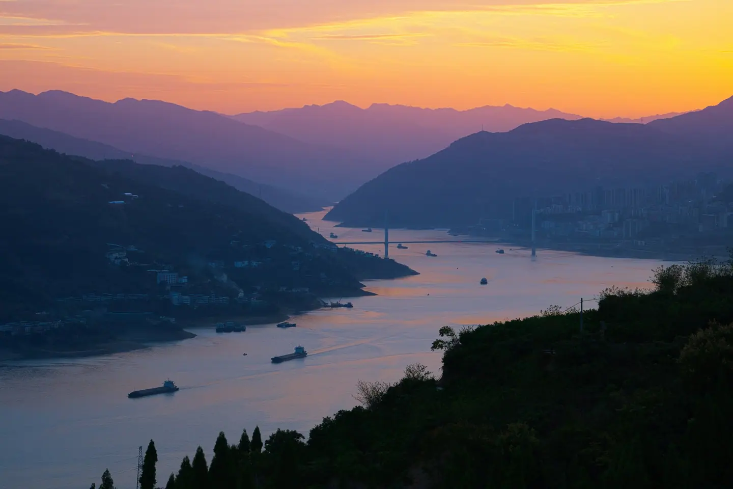 El río Yangtsé entre montañas al atardecer, con barcos, visto desde Baidicheng a la entrada de las Tres Gargantas