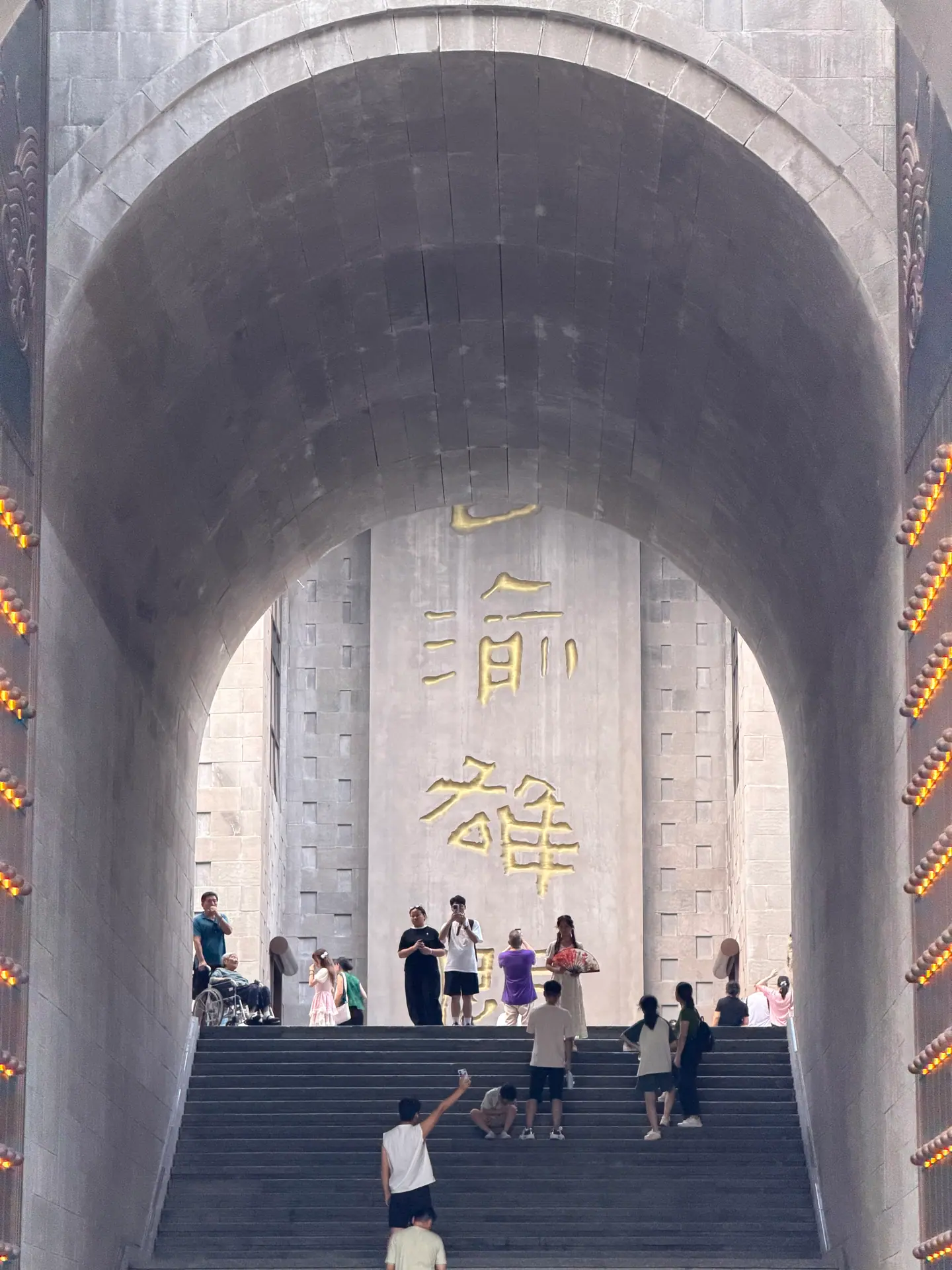 Escalinata bajo un arco monumental con caligrafía dorada en Chaotianmen, Chongqing