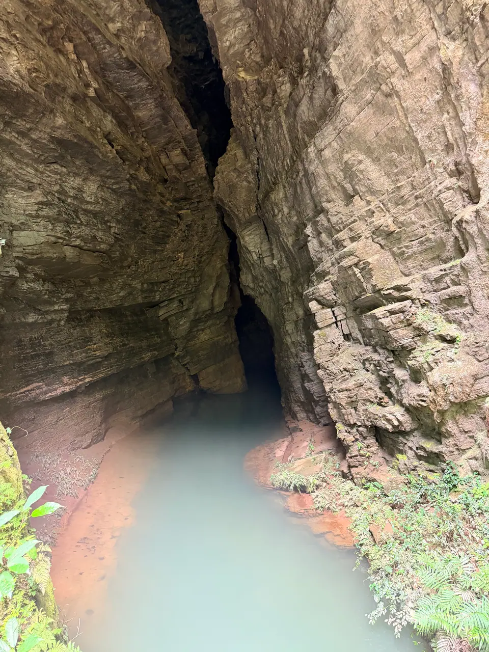 Estrecha grieta de roca con agua turquesa en el Gran Cañón de Zhangjiajie