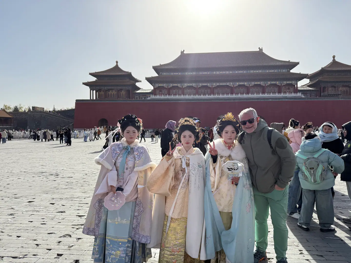 Jóvenes con trajes de hanfu de invierno y un viajero en la explanada de la Puerta Meridiana, en la Ciudad Prohibida