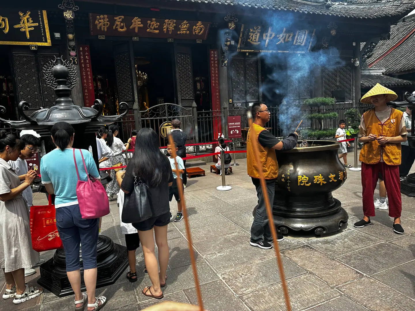 Fieles ofreciendo incienso ante un gran pebetero en el monasterio Wenshu, Chengdu