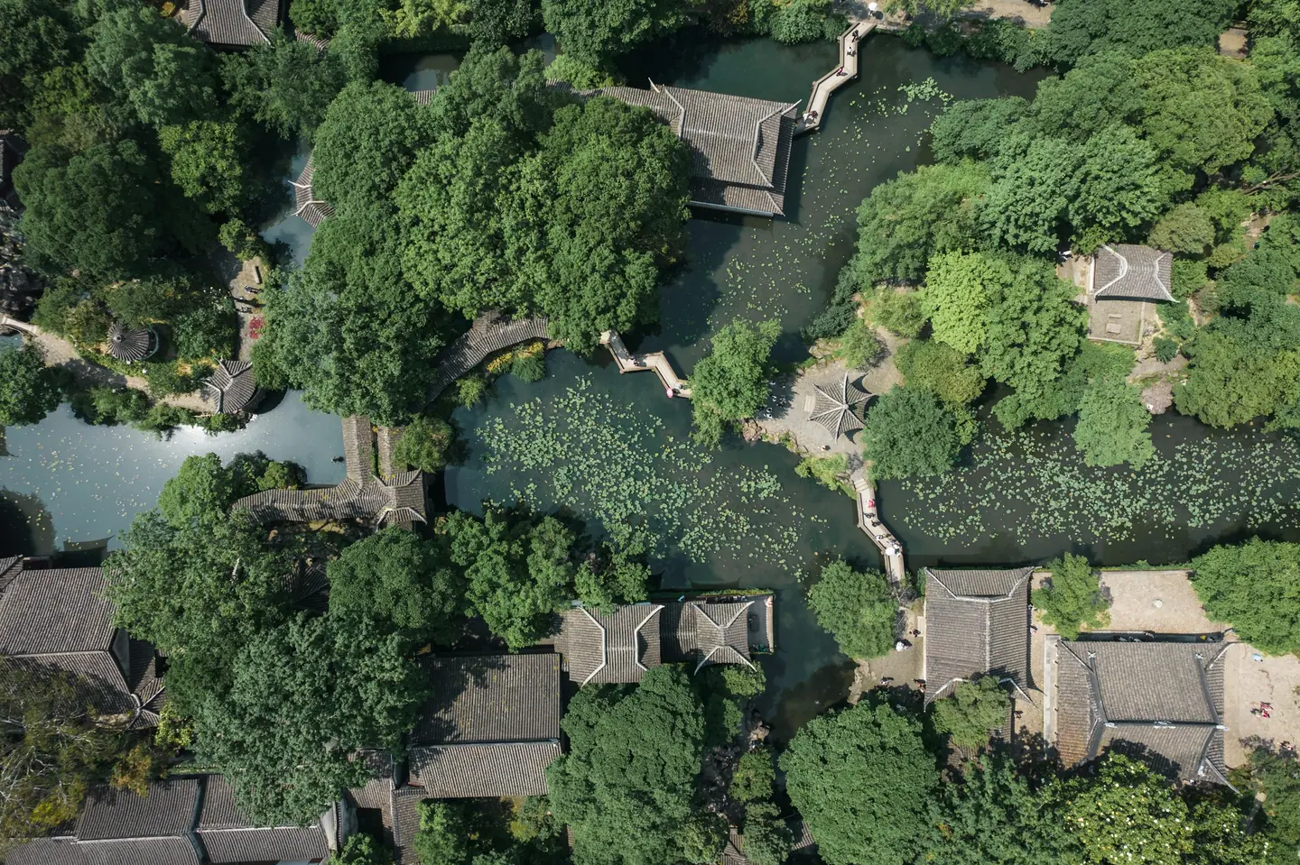 Vista aérea del Jardín del Administrador Humilde de Suzhou, con pabellones, puentes y estanques de lotos entre árboles