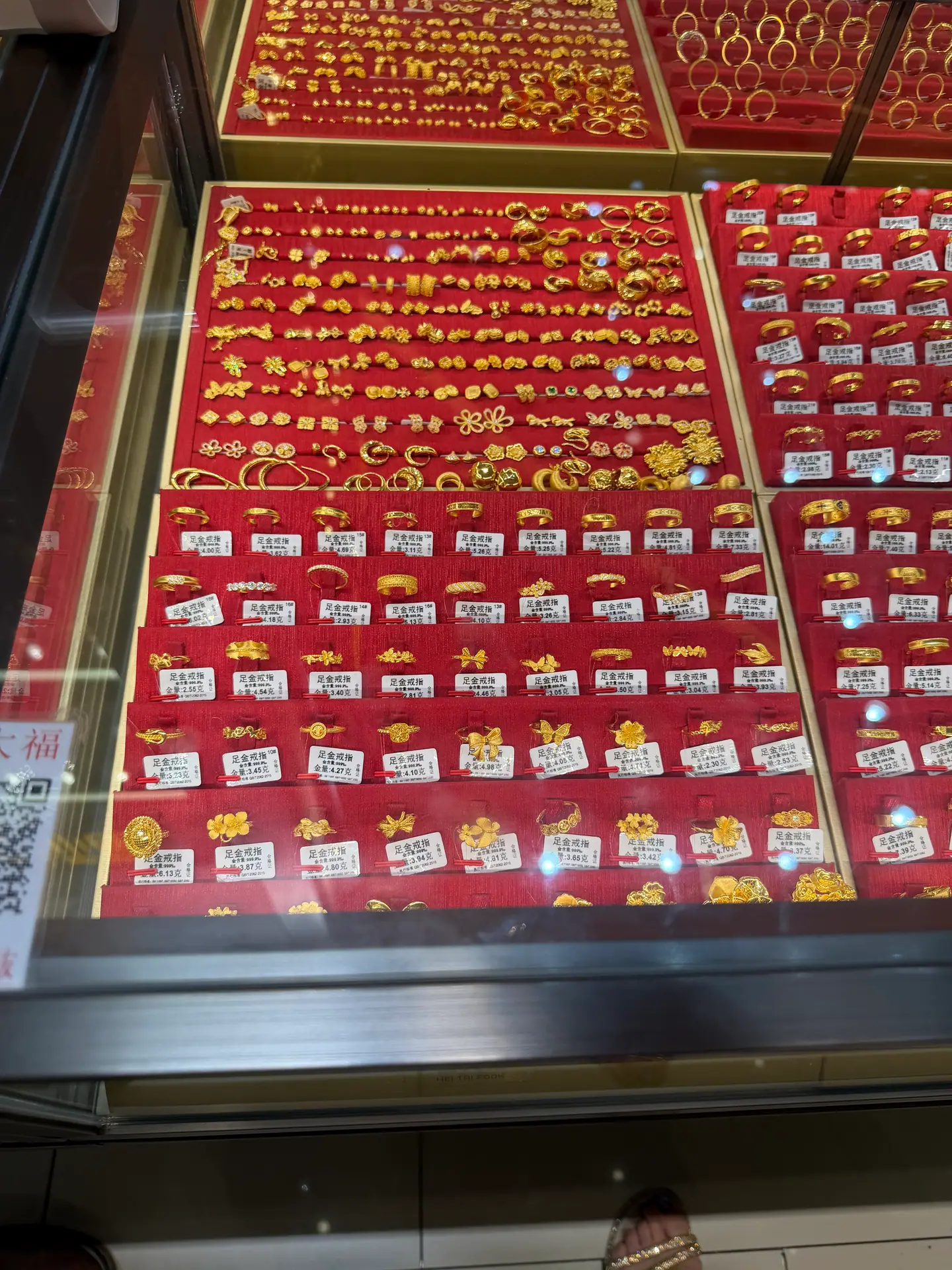 Expositor de anillos y colgantes de oro sobre terciopelo rojo en Shuibei, Shenzhen