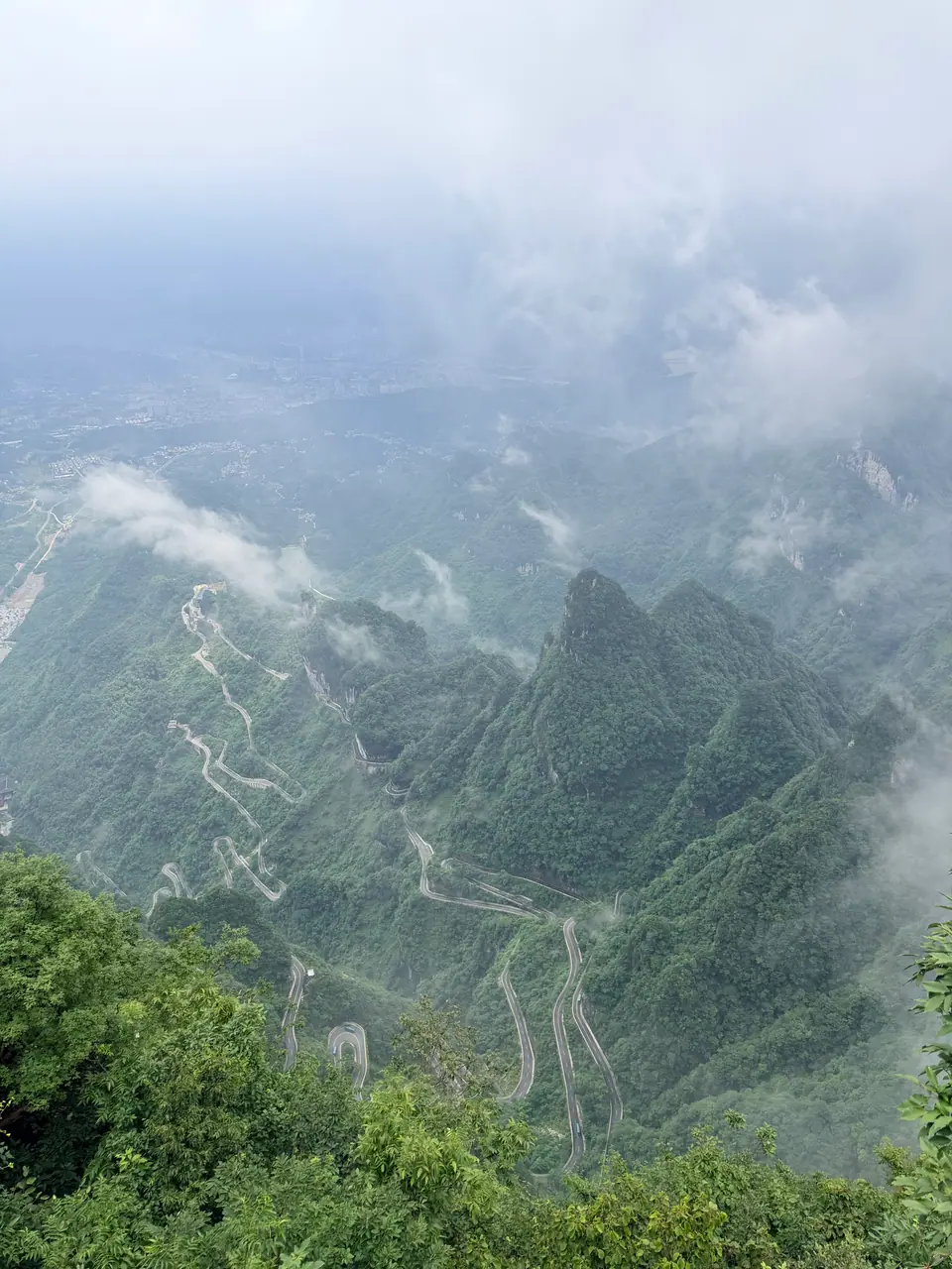 Carretera de curvas entre montañas brumosas vista desde la montaña Tianmen