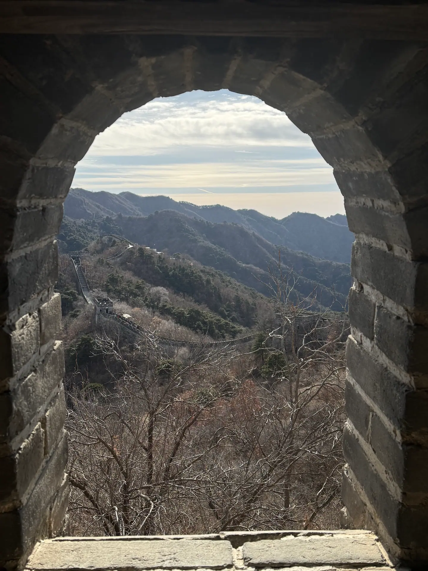 Montañas y la Gran Muralla vistas a través de una ventana en arco de una atalaya