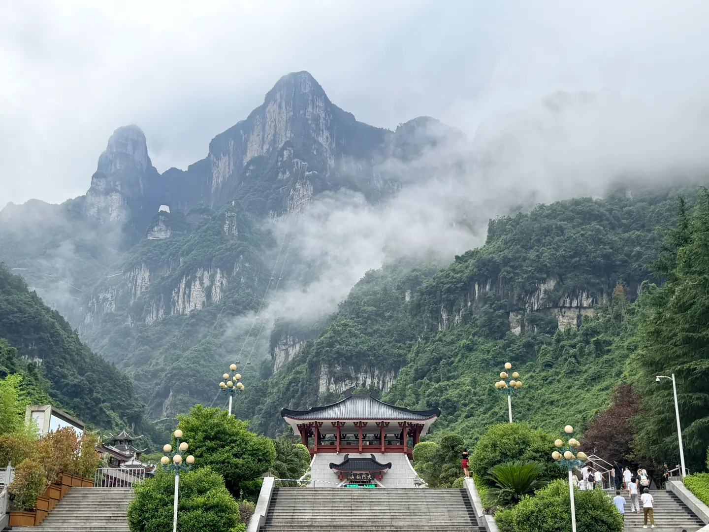 La montaña Tianmen y su arco natural entre nubes sobre el valle verde, Zhangjiajie