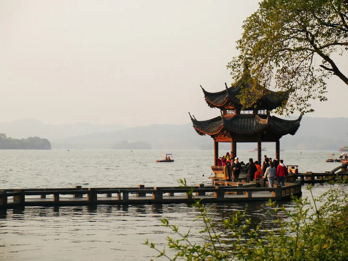 Pabellón tradicional sobre el Lago del Oeste de Hangzhou con montañas entre la bruma
