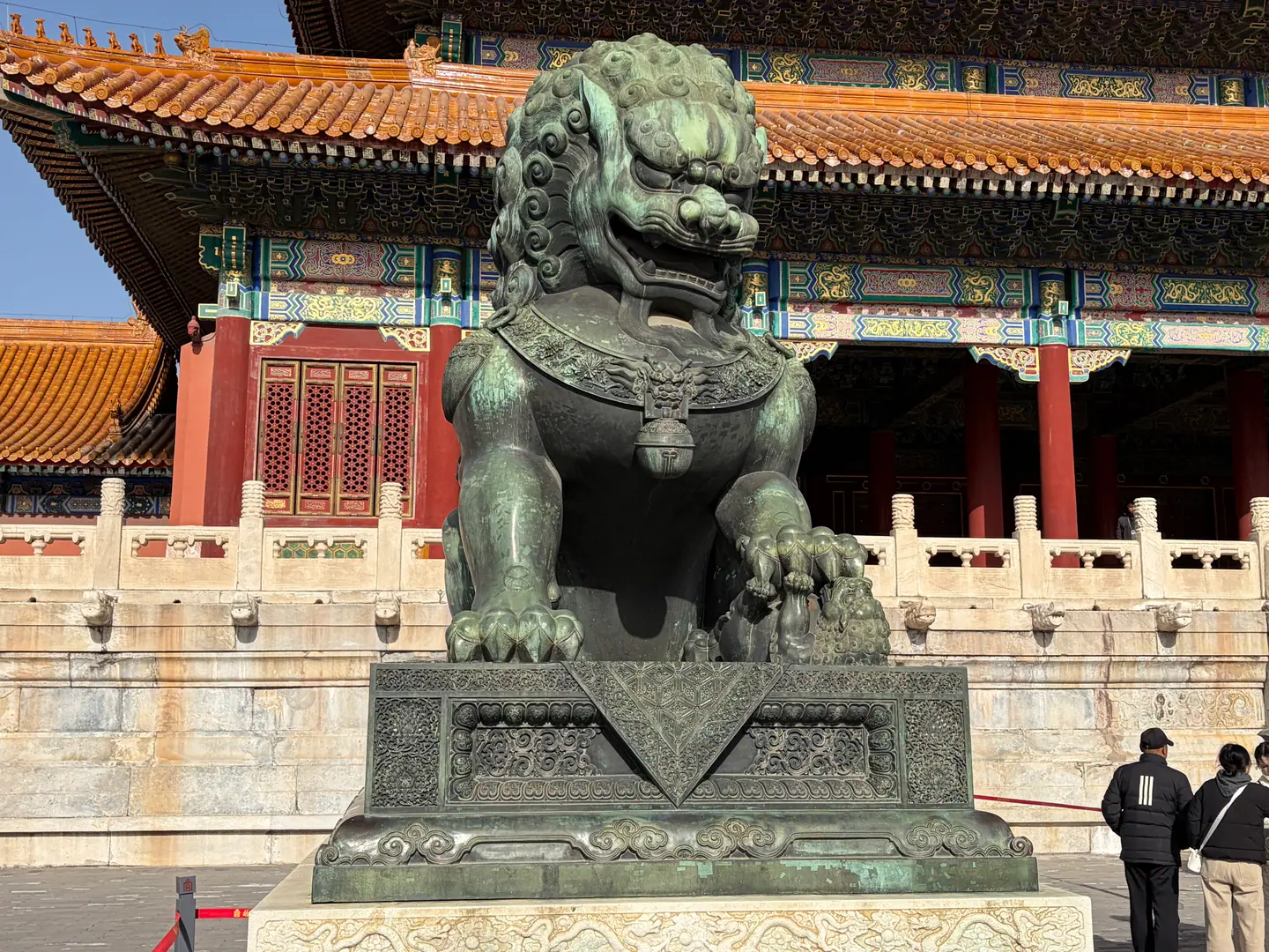 León guardián de bronce ante un salón de tejados dorados en la Ciudad Prohibida, Pekín