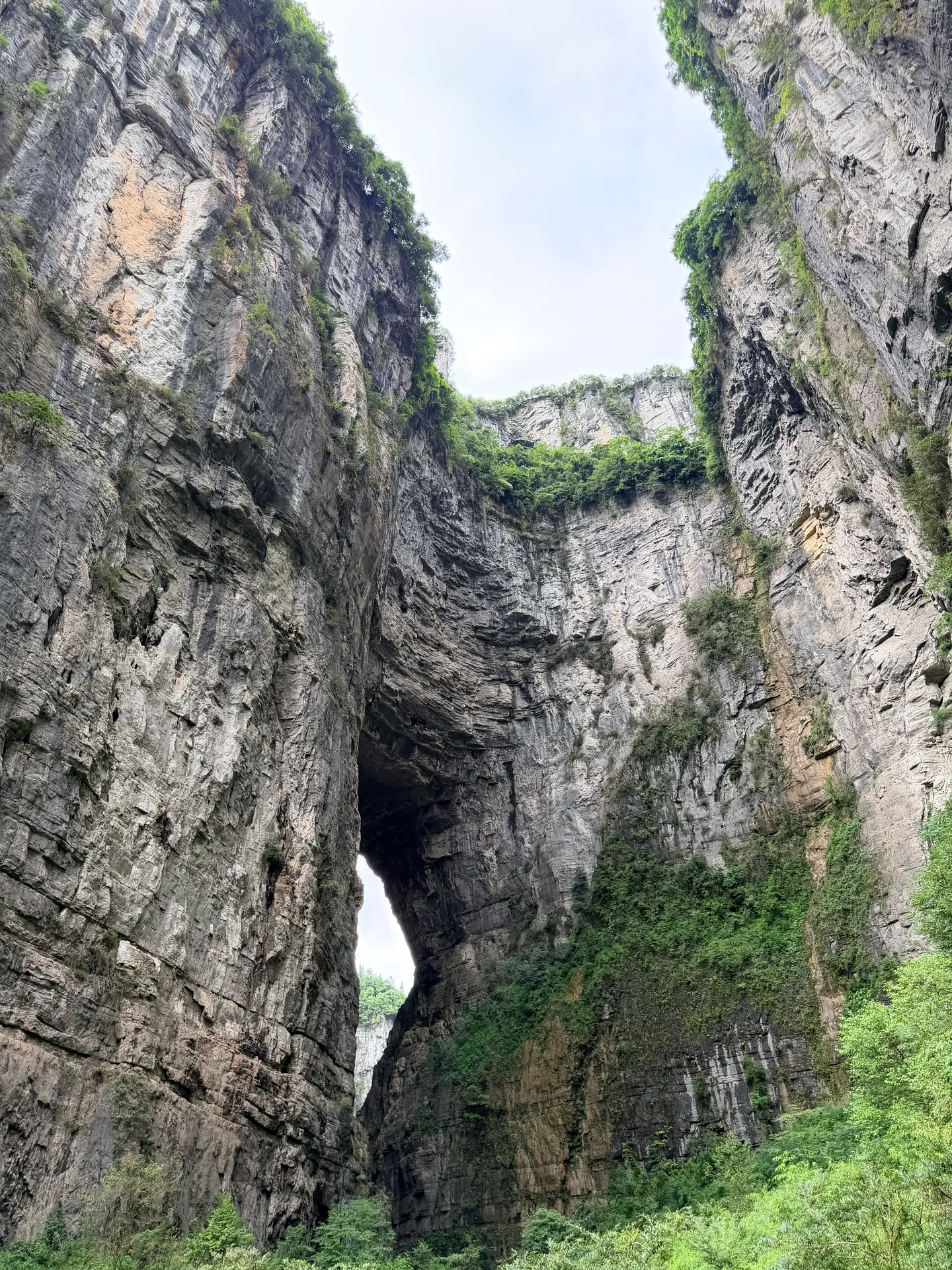Arco de un puente natural entre paredes verticales en los Tres Puentes Naturales de Wulong