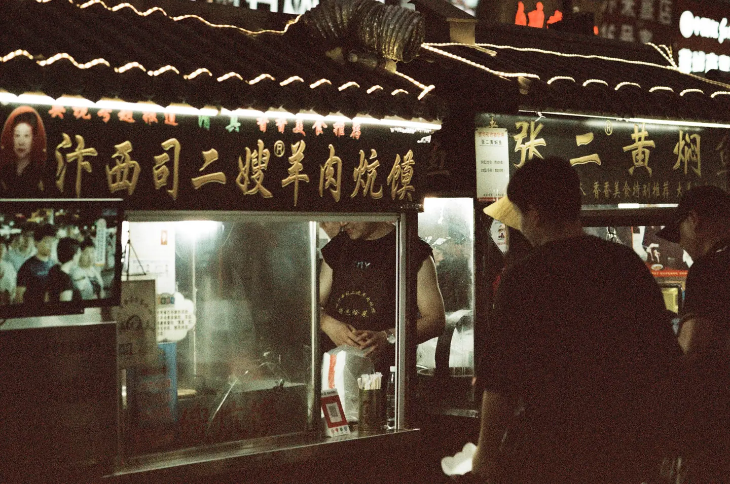 Puesto de comida iluminado en un mercado nocturno de Kaifeng