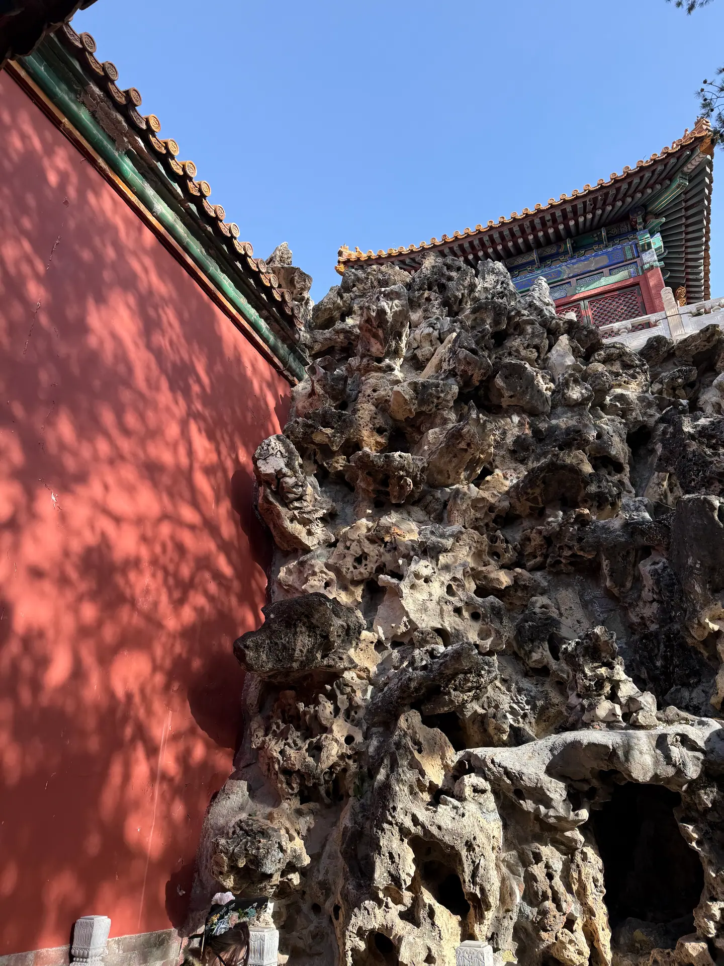 Muro rojo y rocalla en un jardín de la Ciudad Prohibida bajo el cielo azul de invierno