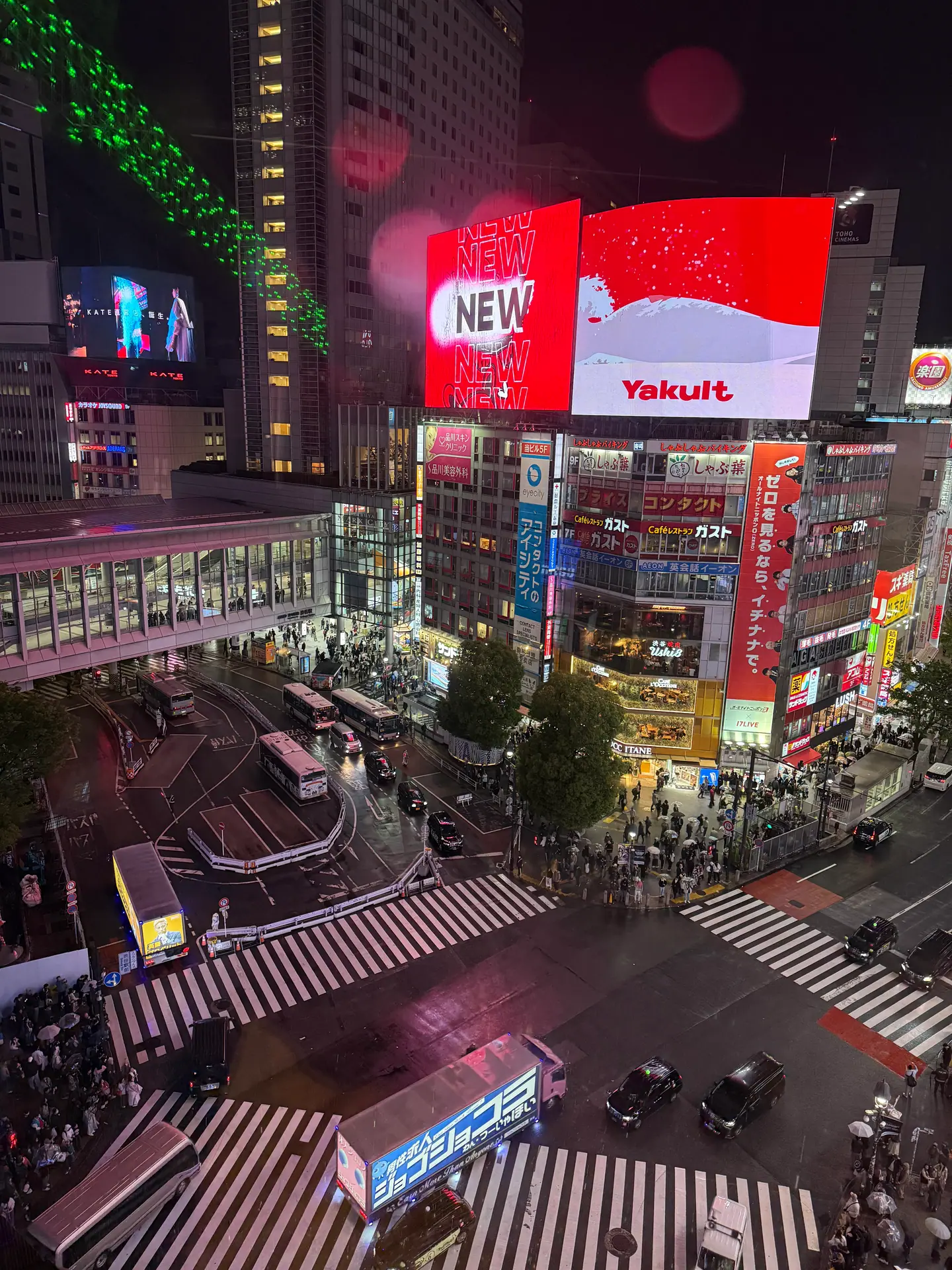 Pasos de cebra del cruce de Shibuya vistos desde arriba de noche bajo pantallas gigantes iluminadas, Tokio