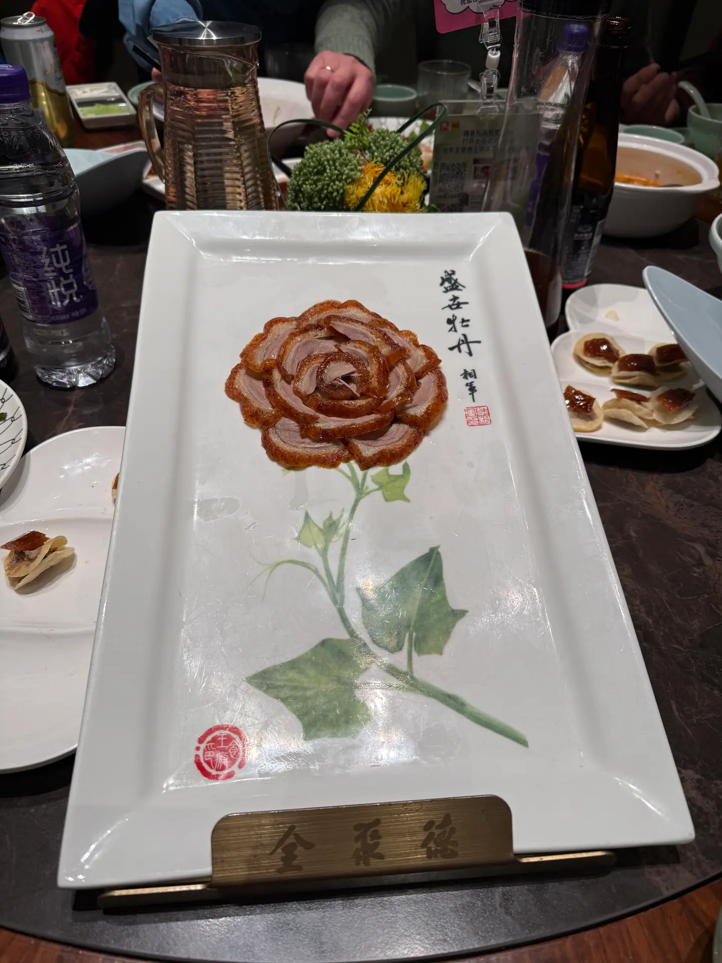 Bandeja con flor dibujada y platos de un banquete de pato laqueado en Pekín
