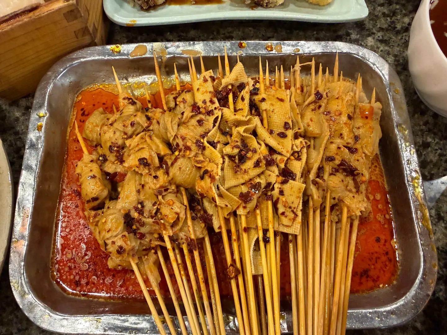 Bandeja de pinchos en caldo picante, típica comida callejera de Henan