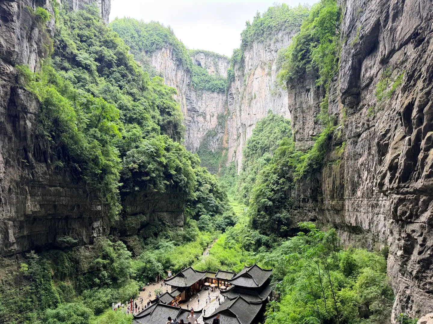 Antigua posta Tianfu entre paredes de roca gigantescas en el fondo del cañón de Wulong