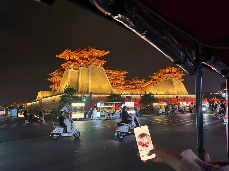 La puerta Yingtianmen de Luoyang iluminada de noche vista desde la calle