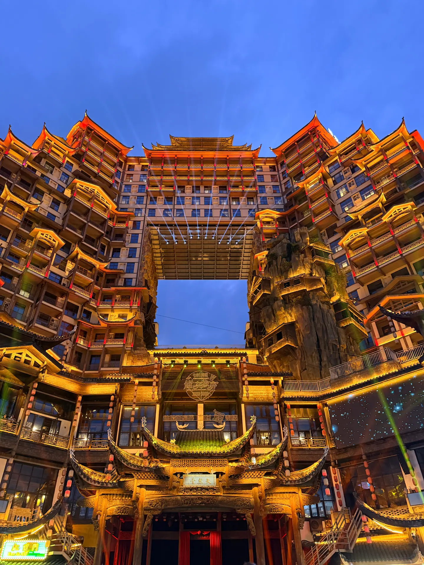 Fachadas de madera iluminadas en dorado del complejo de las 72 Torres en Zhangjiajie
