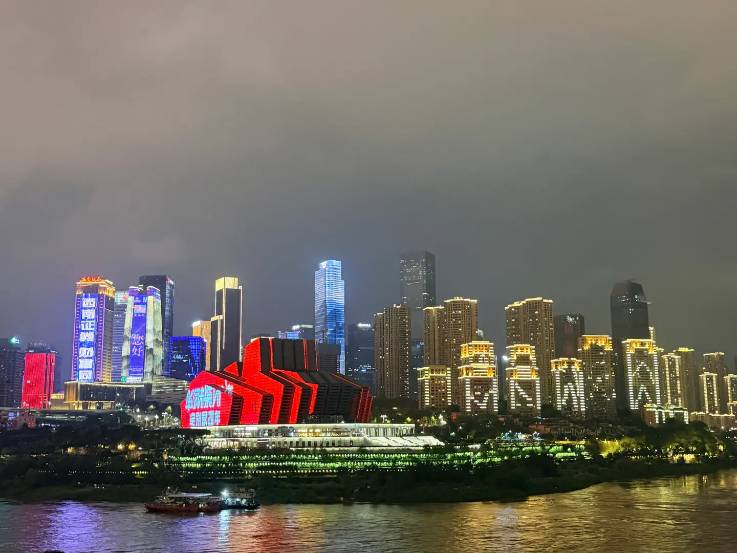 Rascacielos iluminados de Chongqing reflejados en el río al anochecer