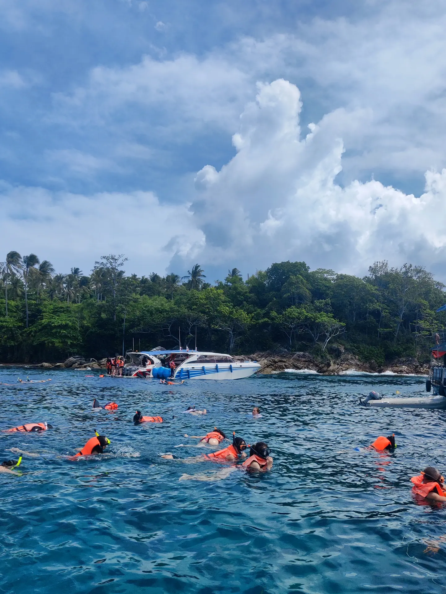 Bañistas haciendo snorkel en aguas turquesas frente a una isla tropical cerca de Phuket