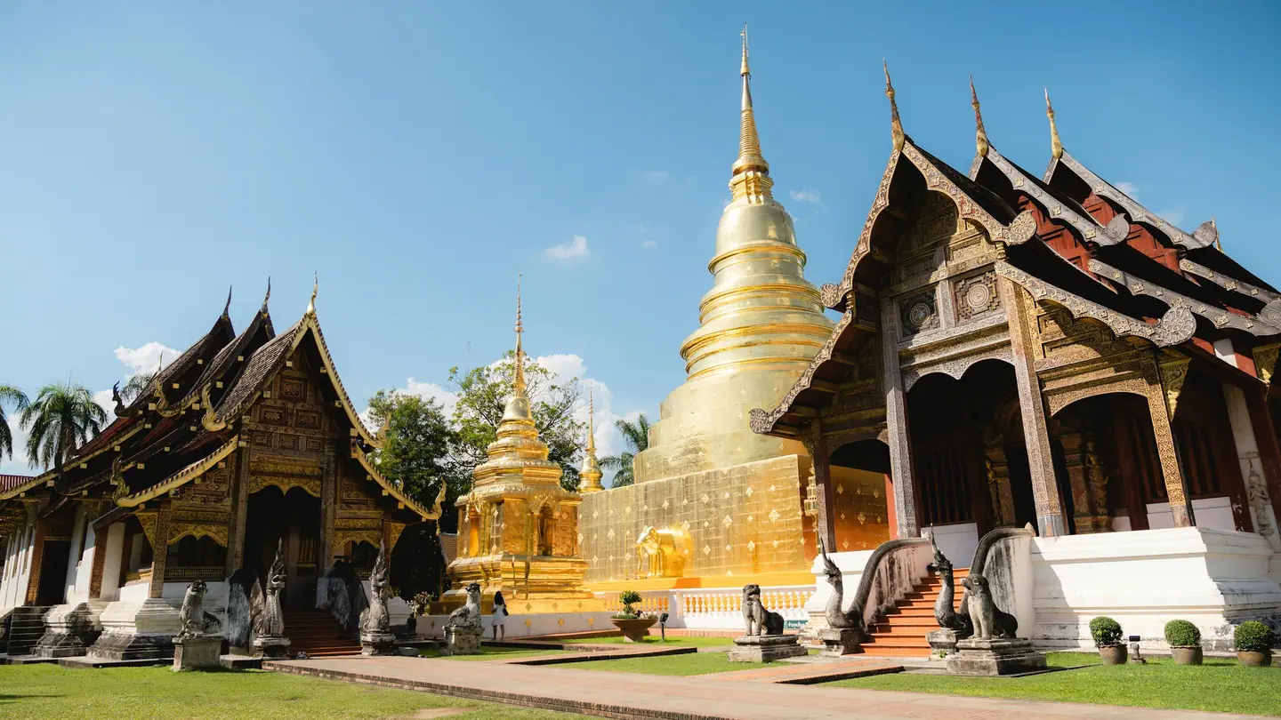 Salas de madera tallada de estilo lanna y chedi dorada de un templo del casco antiguo de Chiang Mai