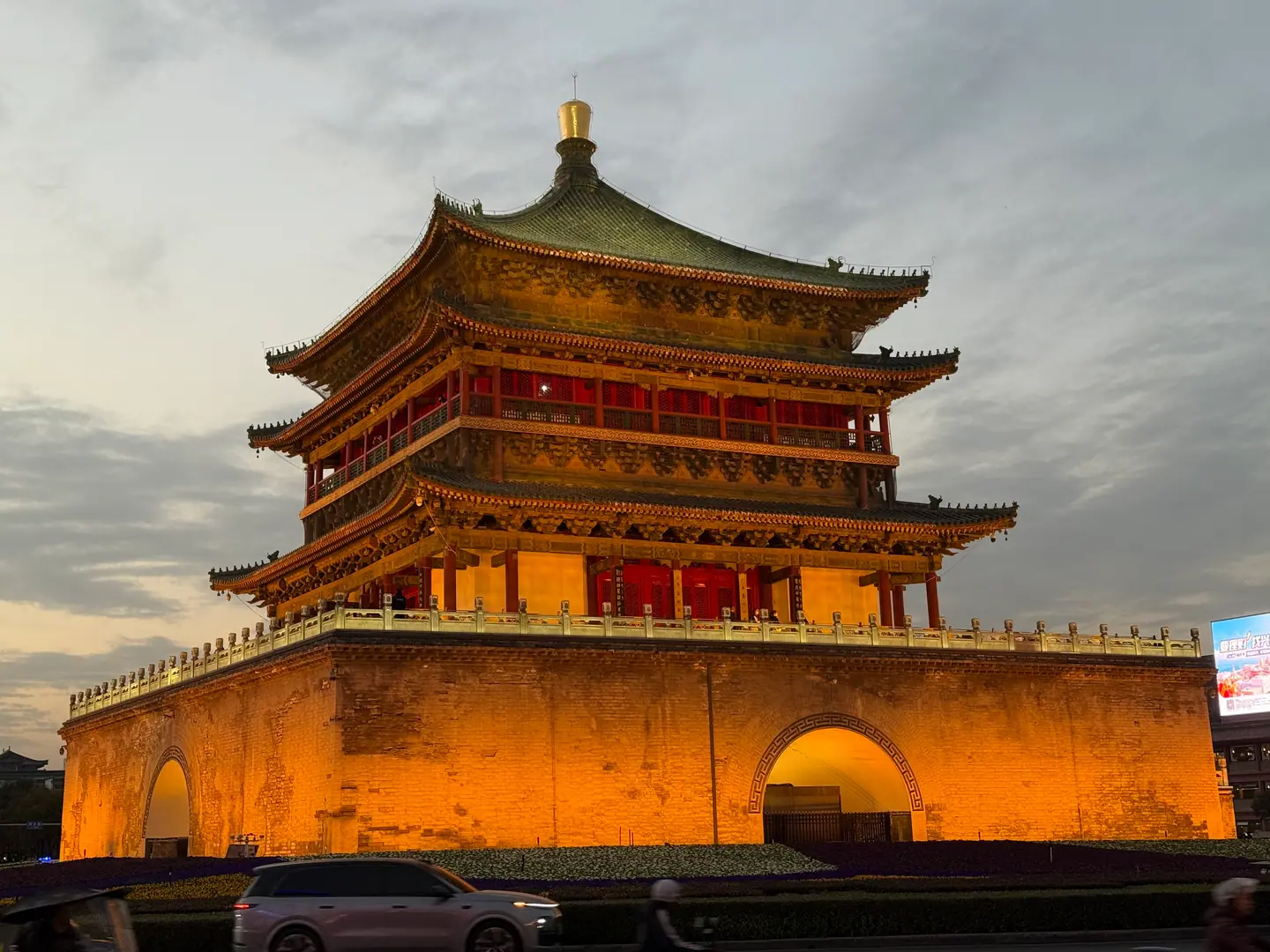 La Torre de la Campana de Xi'an iluminada al anochecer bajo un cielo nublado