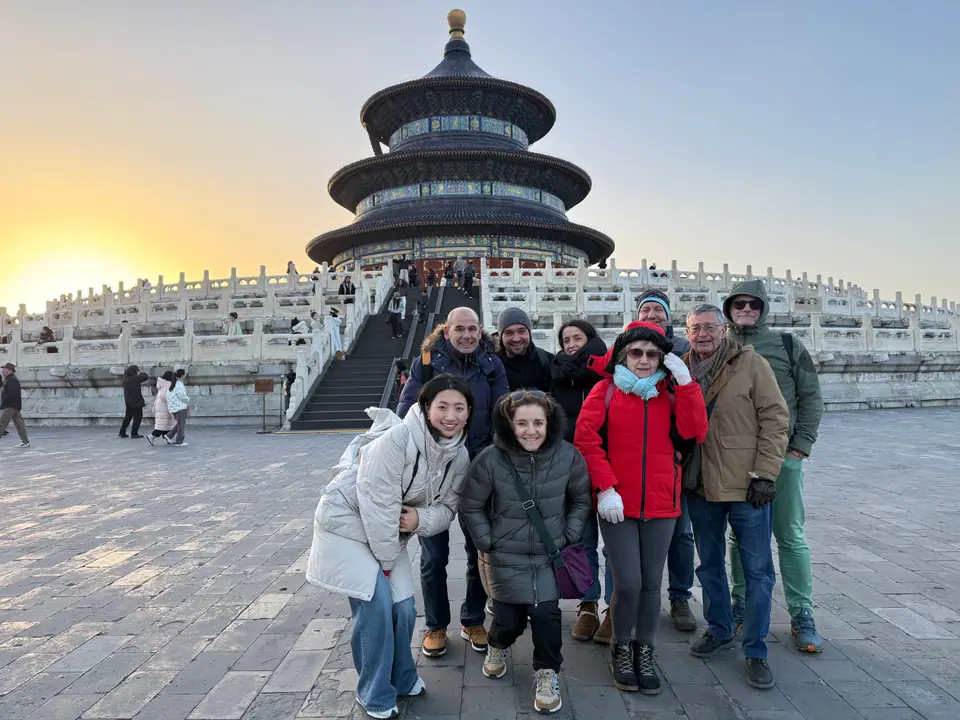 Grupo de viajeros ante el Salón de la Oración del Templo del Cielo al atardecer